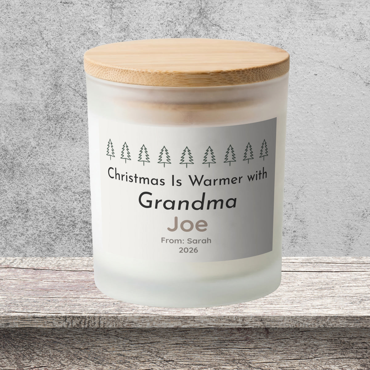 DESIGN F - Christmas Is Warmer with Grandma personalized frosted candle on a stone backdrop