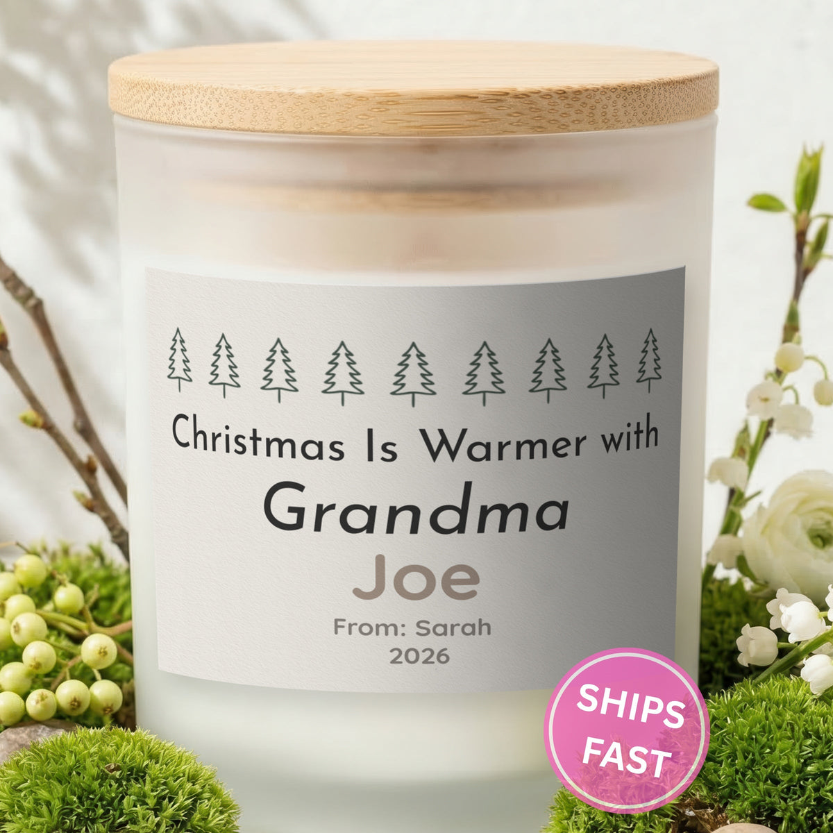 Christmas Is Warmer with Grandma personalized frosted candle with bamboo lid in a lifestyle scene with greenery