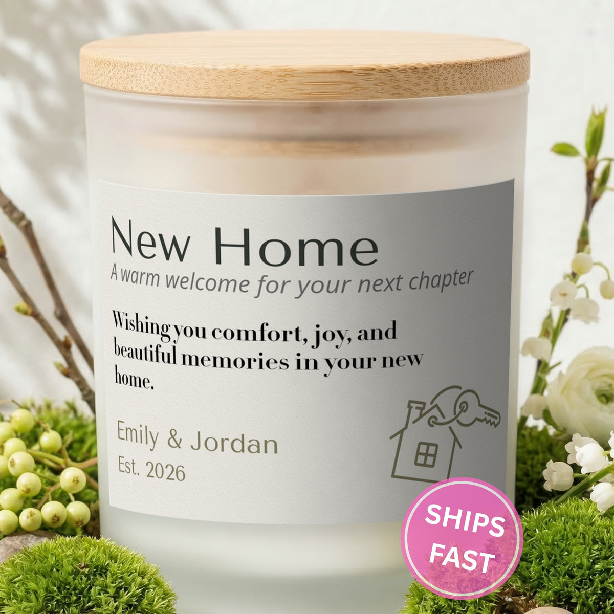 A Warm Welcome for Your Next Chapter personalized frosted candle with bamboo lid in a lifestyle scene with greenery