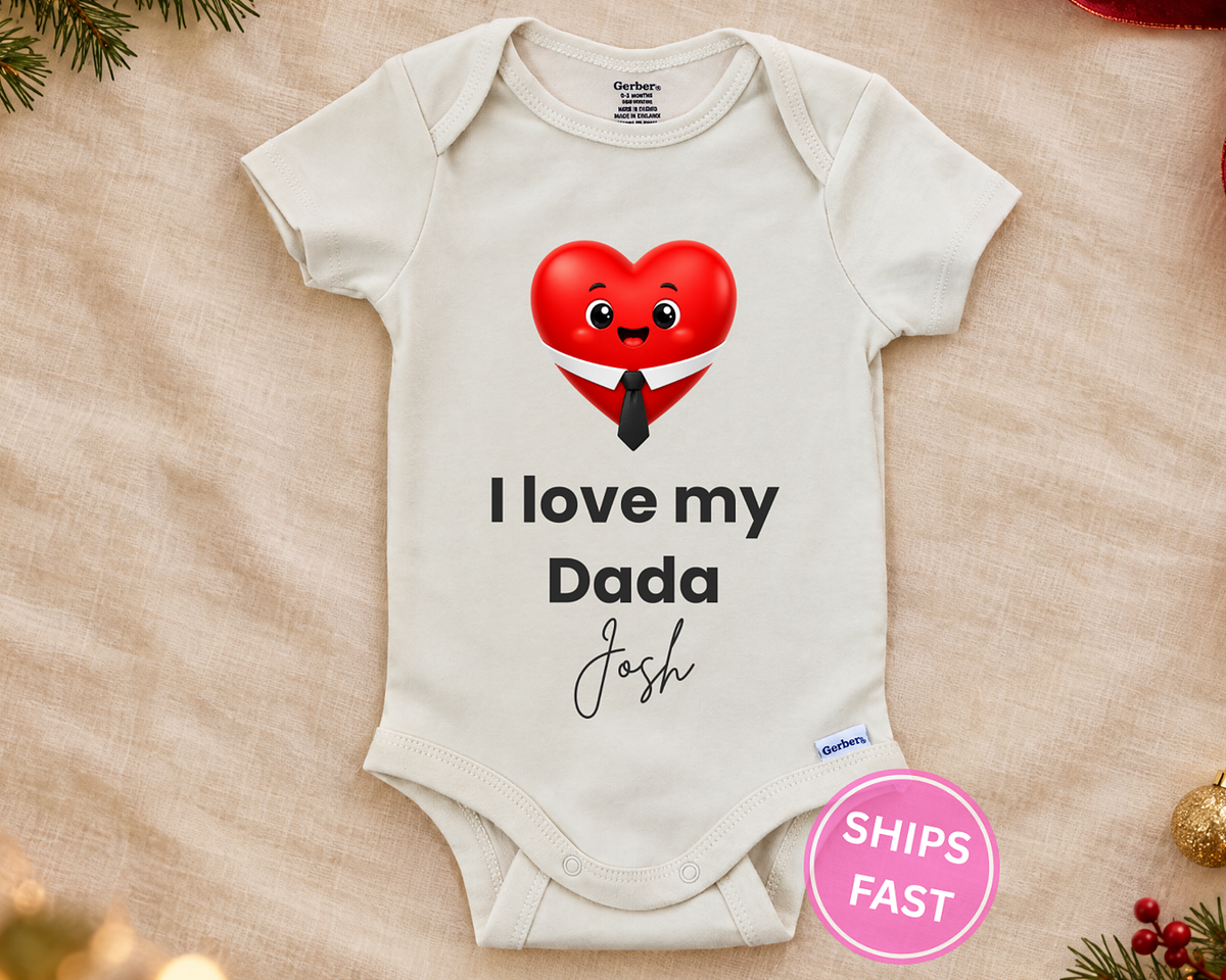I Love My Dada personalized baby bodysuit with smiling red heart in a shirt and tie on a cream blanket
