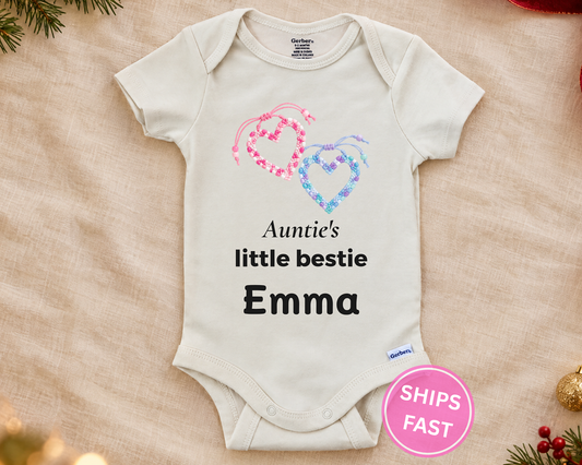 Auntie's Little Bestie personalized baby bodysuit with beaded friendship hearts on a cream blanket