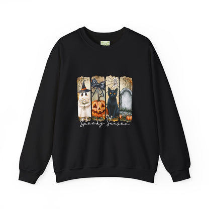 Black sweatshirt with Halloween-themed decor: a witch, pumpkin, black cat, and tombstone for the spooky season.