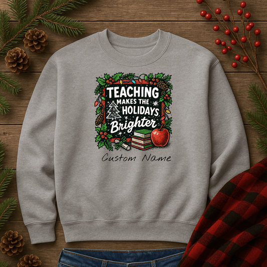 Personalized gray holiday sweatshirt with 'Teaching Makes the Holidays Brighter' design and custom name option.