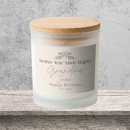 DESIGN A - Another Year Made Brighter personalized frosted candle on a stone backdrop