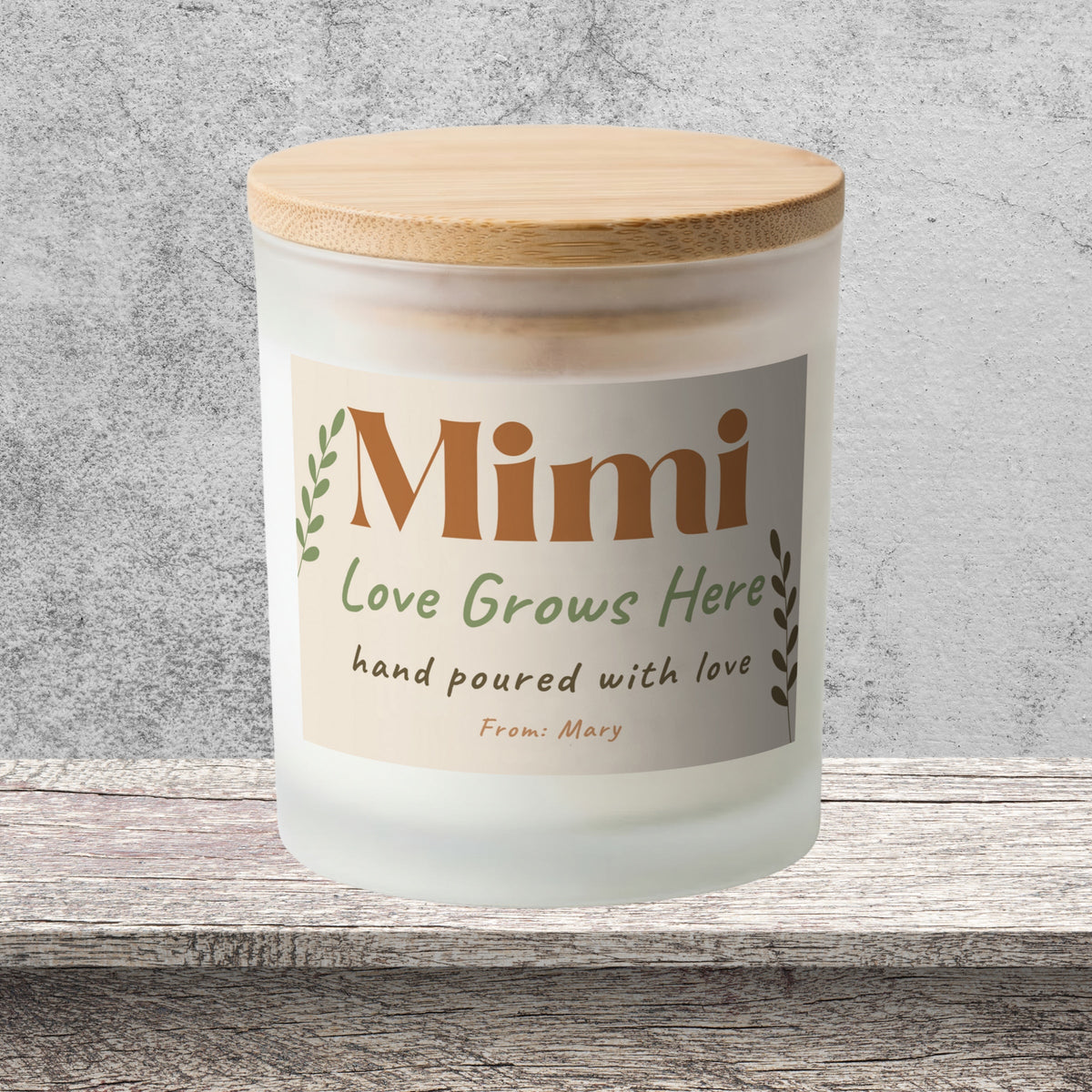 DESIGN D - Love Grows Here personalized frosted candle on a stone backdrop