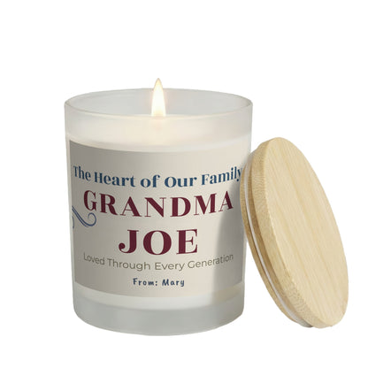 The Heart of Our Family personalized frosted candle, lit with the bamboo lid set aside, on a white background
