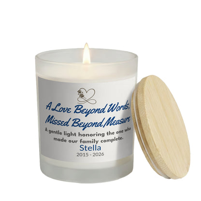 A Love Beyond Words personalized frosted candle, lit with the bamboo lid set aside, on a white background