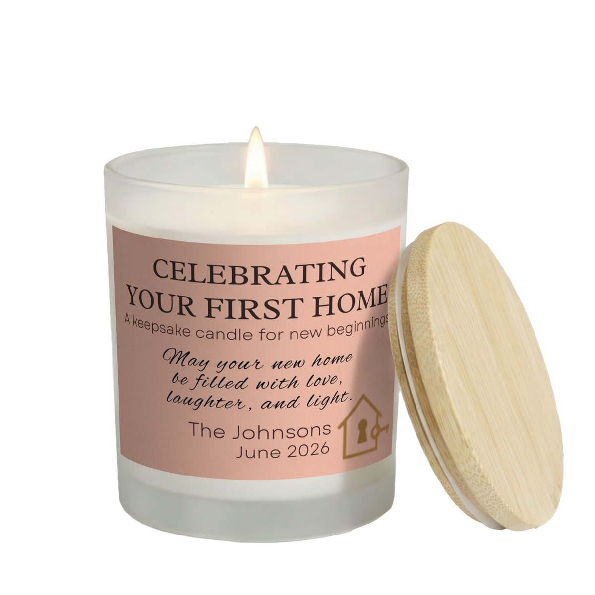 Celebrating Your First Home personalized frosted candle, lit with the bamboo lid set aside, on a white background