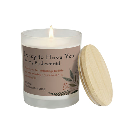 Lucky to Have You personalized frosted candle, lit with the bamboo lid set aside, on a white background