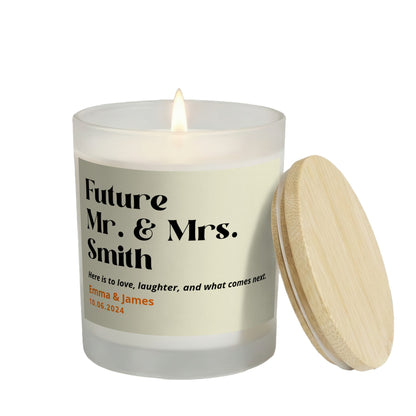 Here Is to What Comes Next personalized frosted candle, lit with the bamboo lid set aside, on a white background