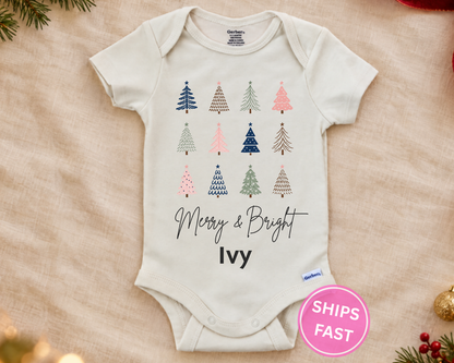 Merry & Bright Christmas trees personalized baby bodysuit laid flat on a soft blanket