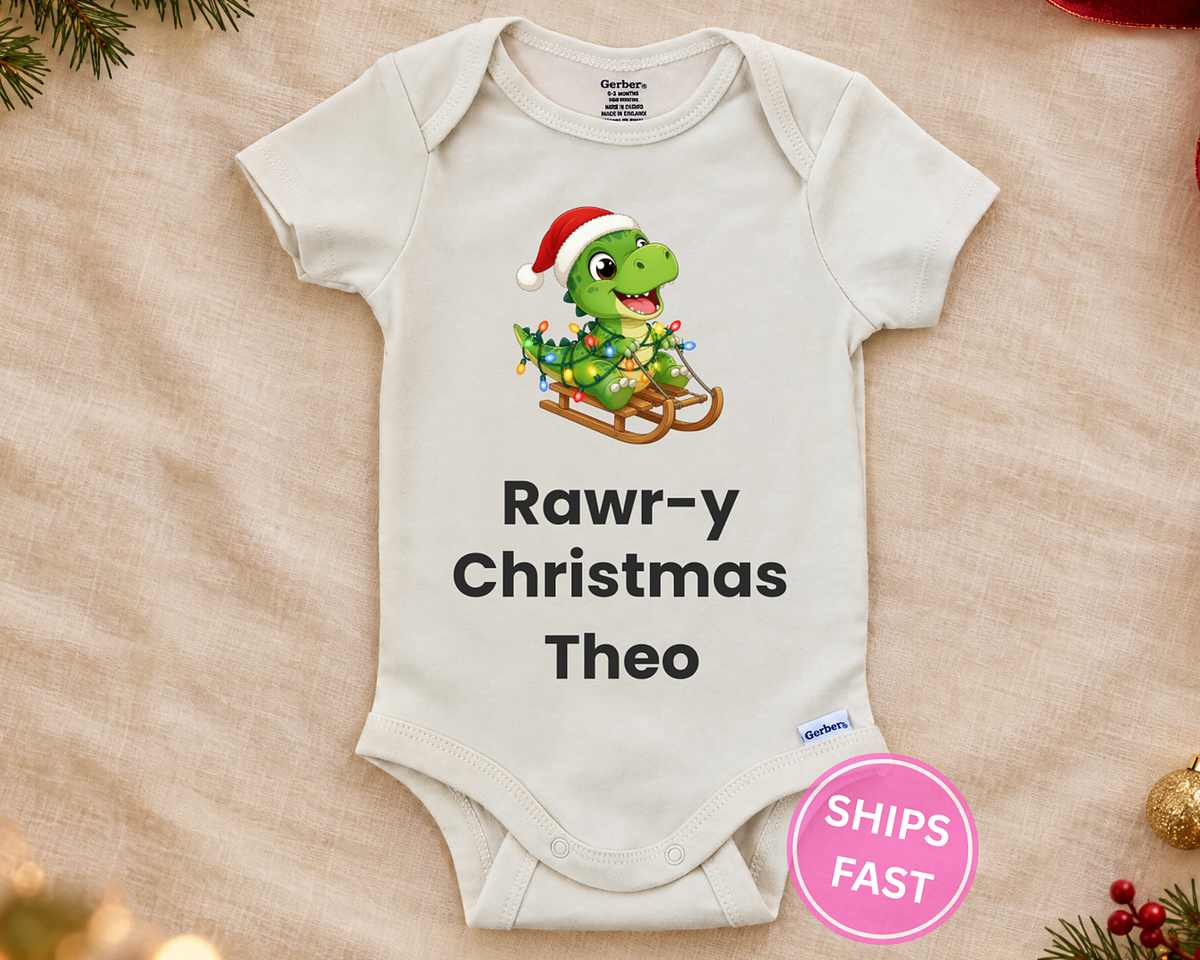 Rawr-y Christmas T-rex personalized baby bodysuit laid flat on a soft blanket