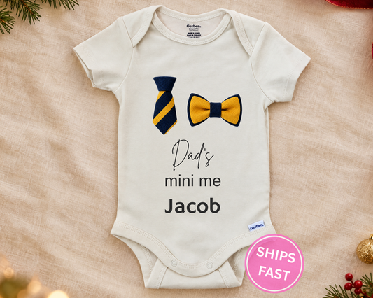 Dad's Mini Me personalized baby bodysuit with striped necktie and bow tie on a cream blanket