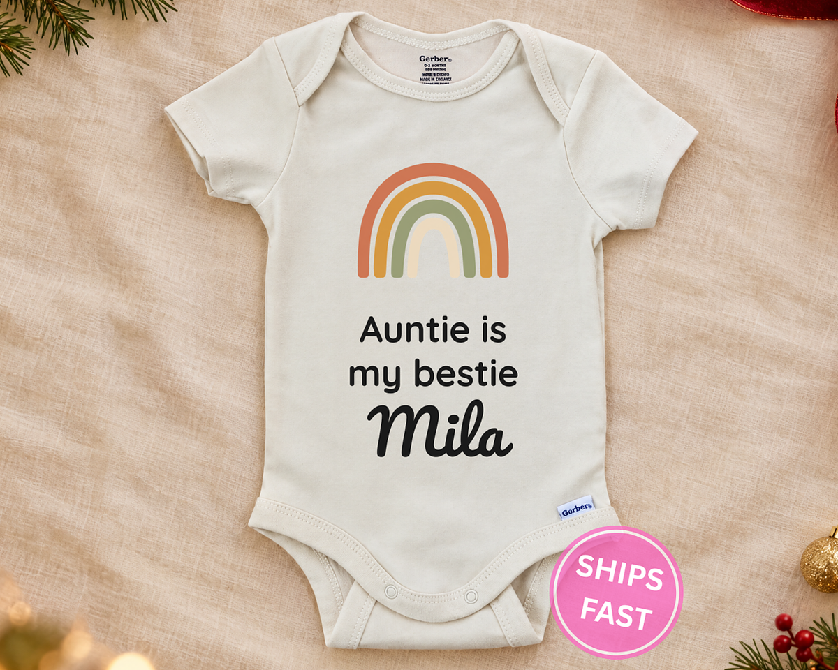 Auntie Is My Bestie personalized baby bodysuit with boho rainbow on a cream blanket