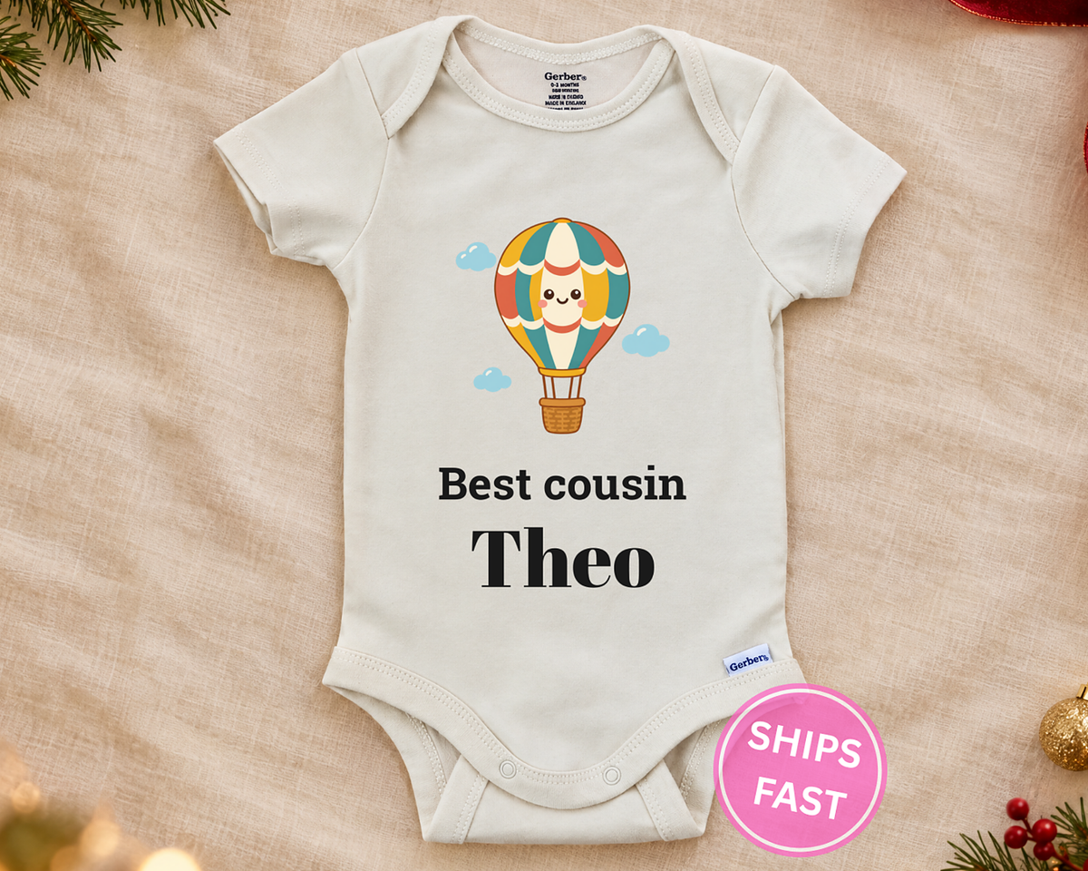 Best Cousin personalized baby bodysuit with the hot air balloon design on a cream blanket