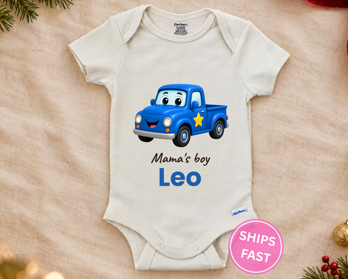 Mama's Boy personalized baby bodysuit with the blue truck design on a cream blanket