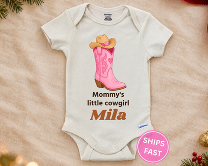 Mommy's Little Cowgirl personalized baby bodysuit with the cowgirl boot design on a cream blanket