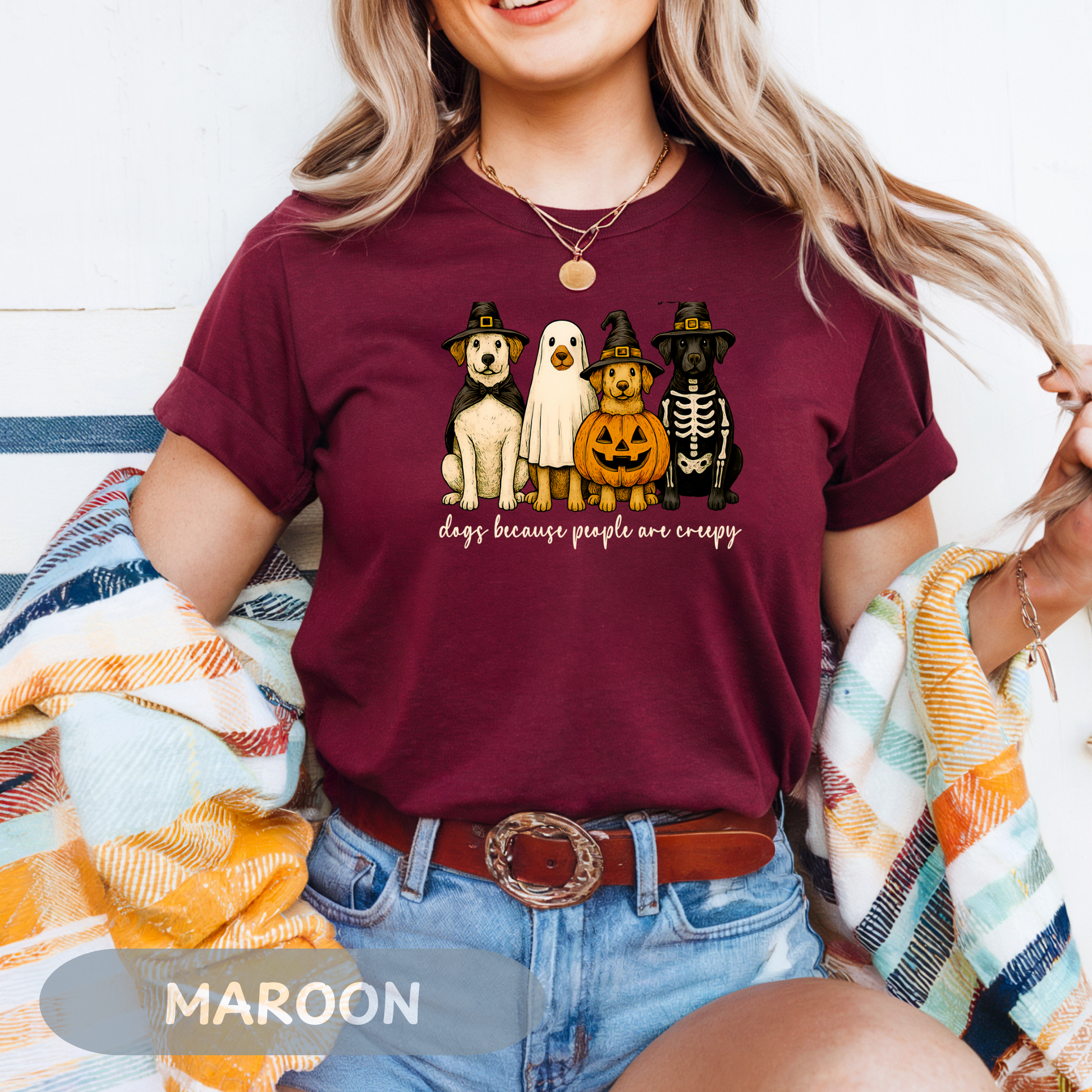 Woman wearing a maroon Halloween Dog Lovers Tee with a ghost, pumpkin, and dogs graphic.