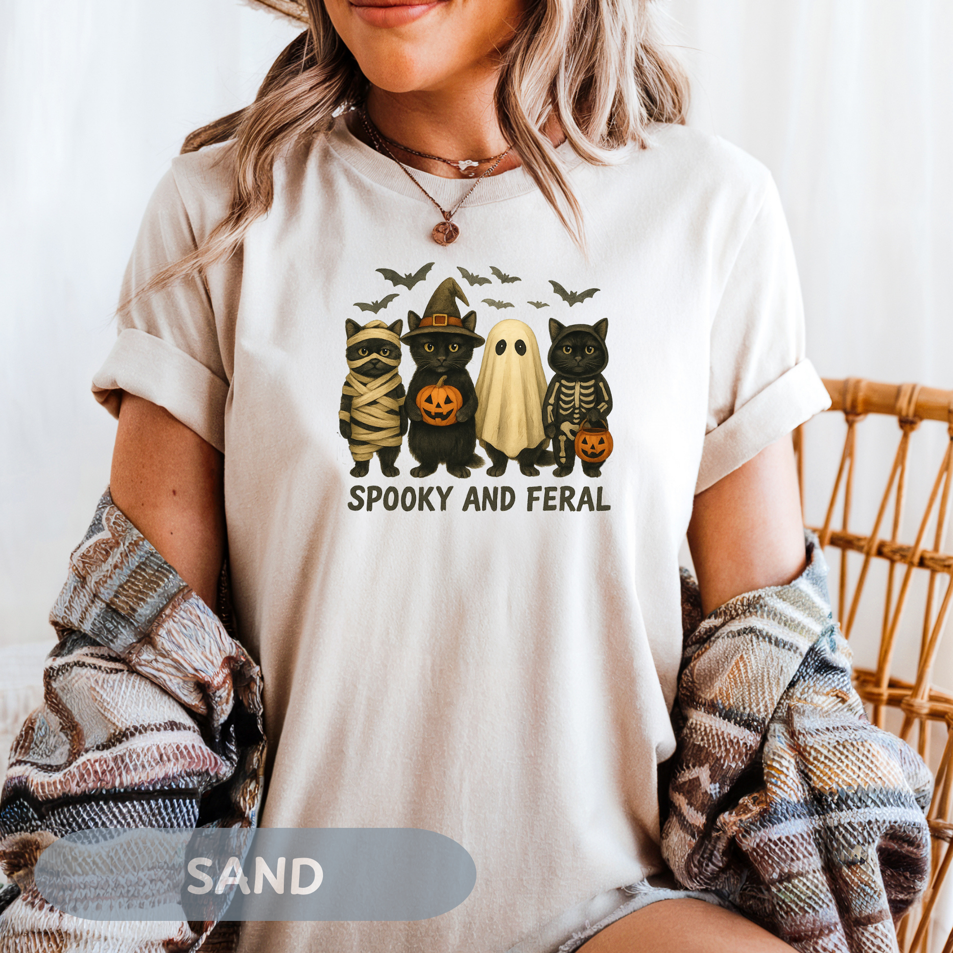 Woman wearing a spooky black cat shirt featuring four cute Halloween characters, perfect for Halloween festivities.