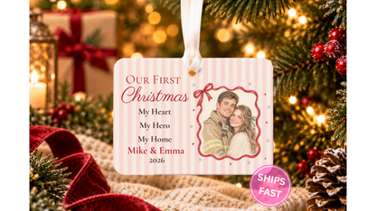 Our First Christmas firefighter couple ornament with a red ribbon photo frame hanging by a ribbon on a Christmas tree with warm lights